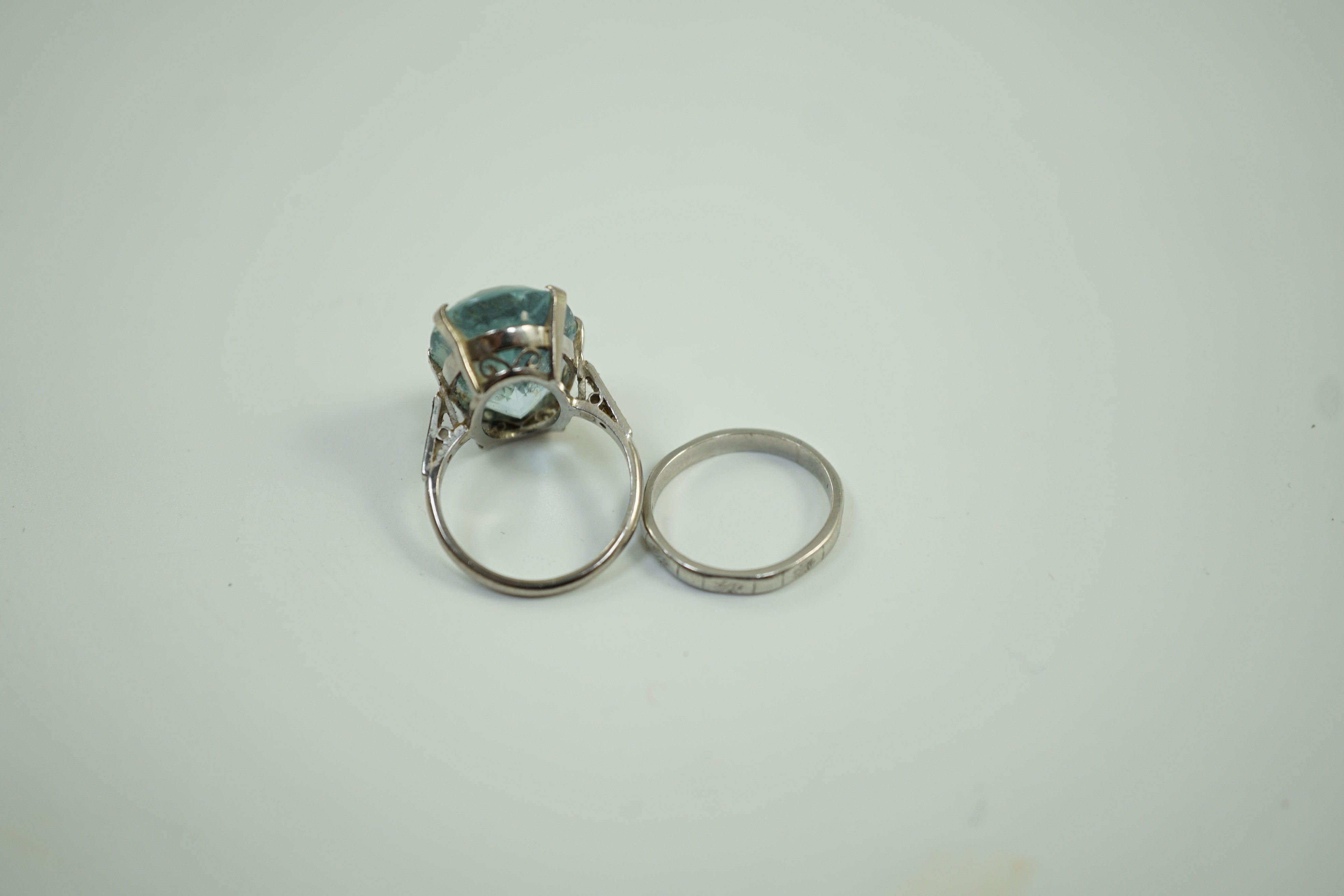 An 18ct, plat and single stone oval cut aquamarine set ring, with diamond chip set shoulders, size K, gross weight 7 grams, together with a white metal, stamped platinum, wedding band, size I, 2.8 grams.